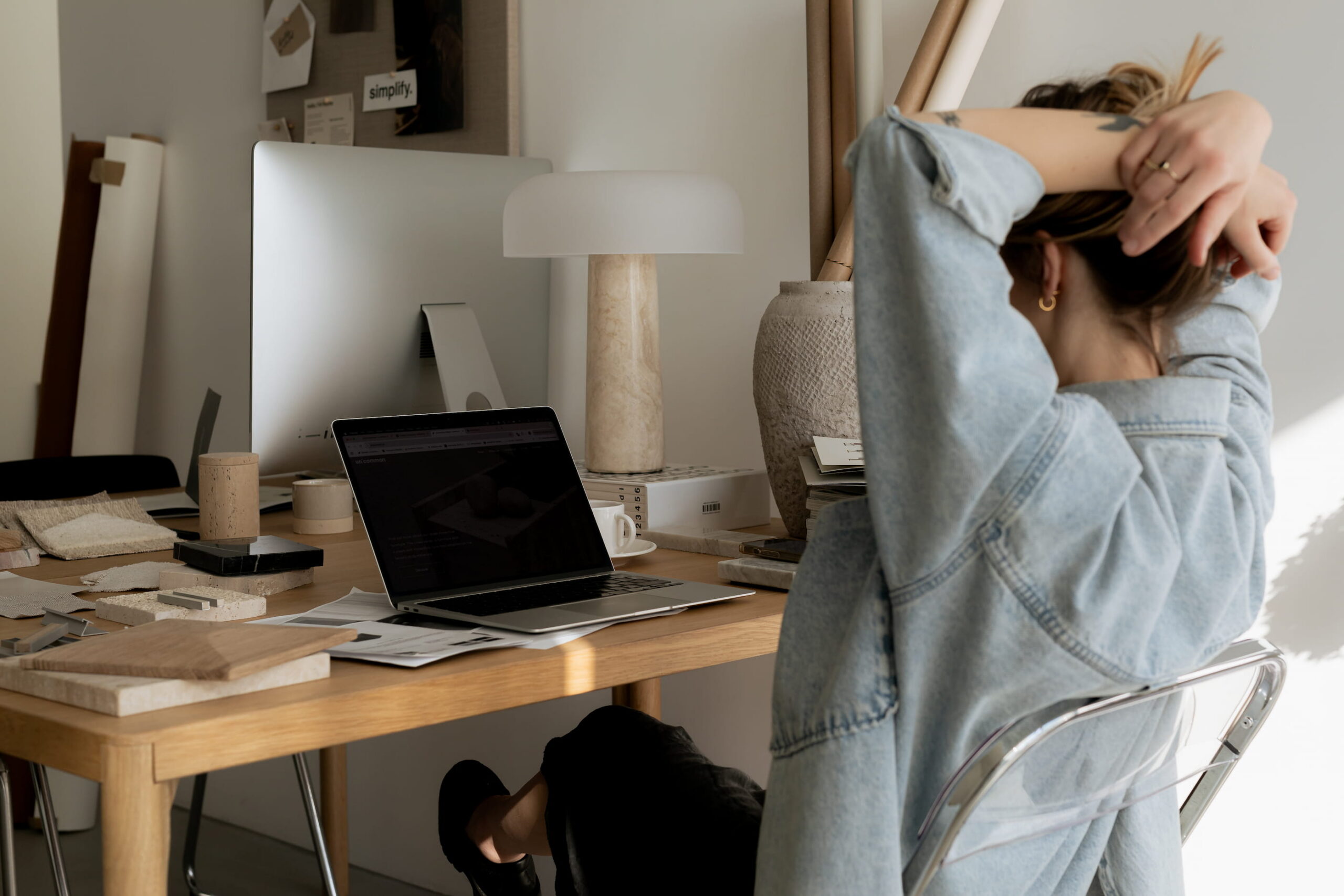 Femme devant son ordinateur hésitant sur l'outil de création de site web à choisir.