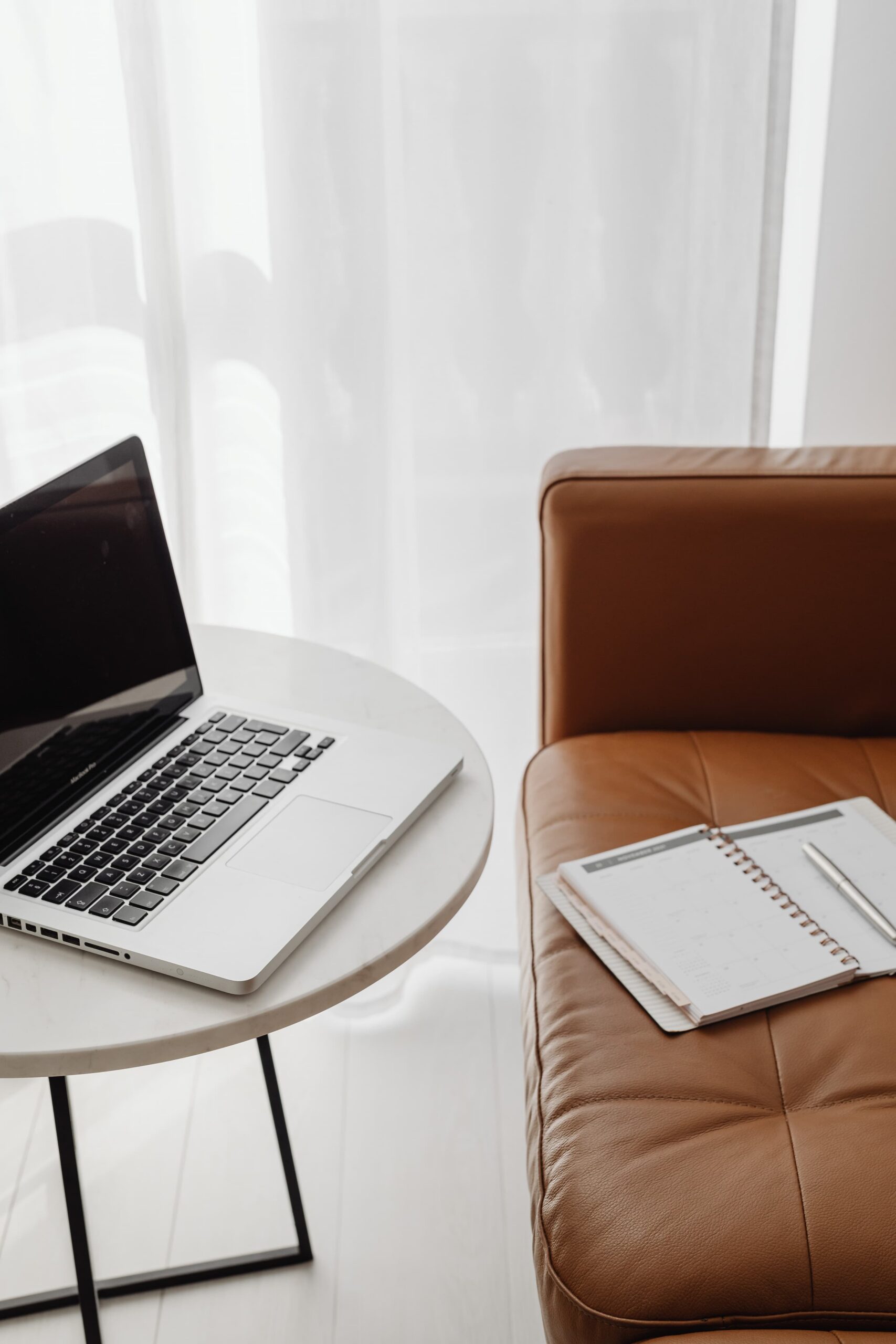 Un cahier posé sur un canapé et un ordinateur. Rien besoin de plus pour créer sa newsletter gratuite.
